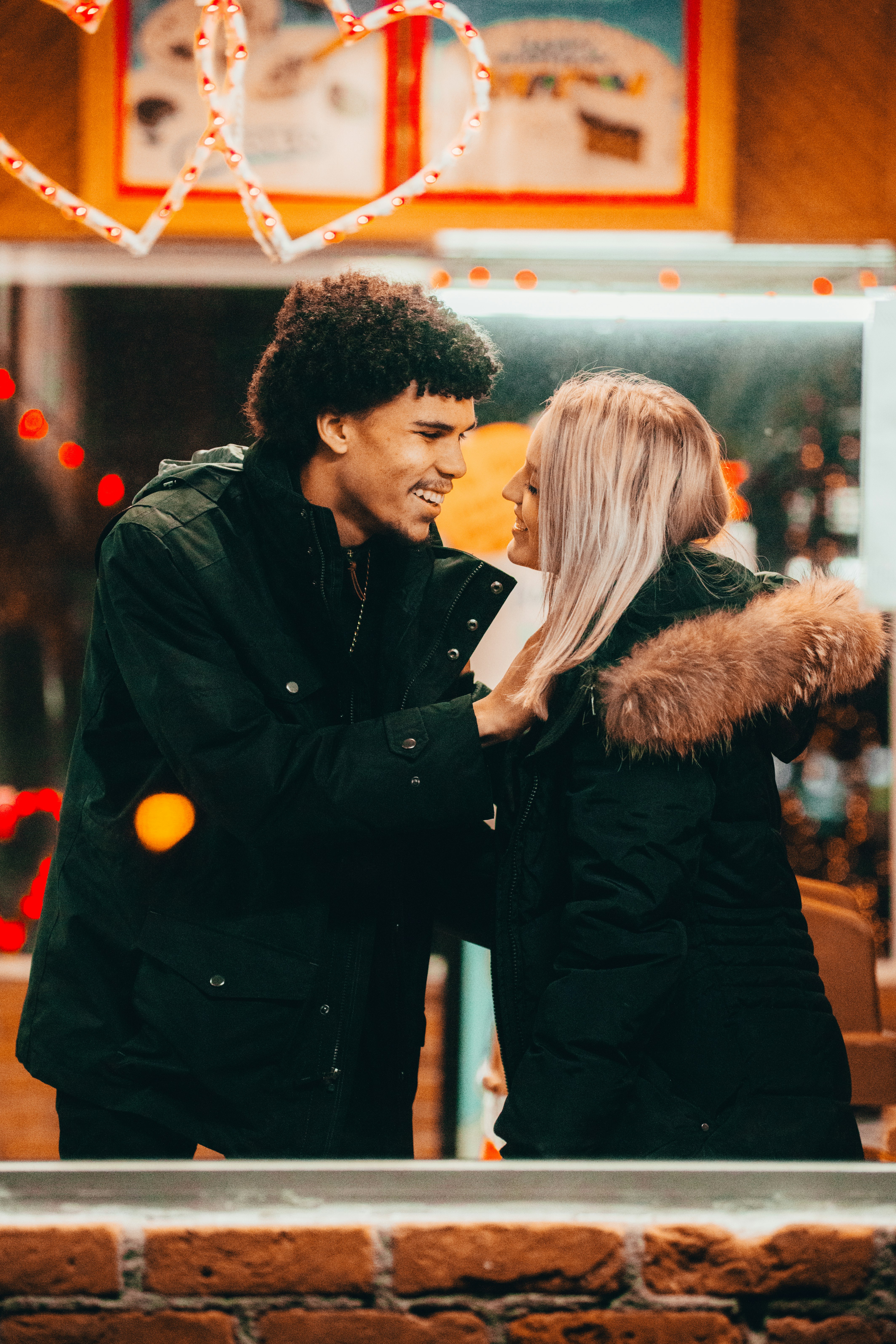 man in black leather jacket standing beside woman in black fur coat